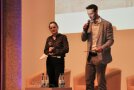 Eine Frau und ein Mann mit Mikrofon und Moderationskarten machen eine Ansage: Julia Träger und Felix Schmidl vom Verein HeimatUnternehmen Bayerische Rhön.